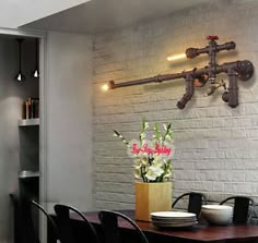 a dining room table with black chairs and a white brick wall