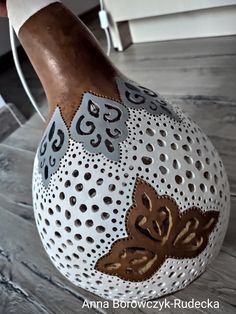 a hand painted vase sitting on top of a wooden floor