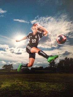 a woman kicking a soccer ball on top of a lush green field under a blue cloudy sky