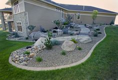 a house with rocks and plants in the front yard
