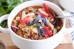 a close up of a bowl of food on a cutting board with a spoon in it