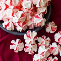 a bowl filled with red and white marshmallows on top of a table