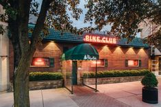 the bike club is lit up at night with its neon sign on it's roof