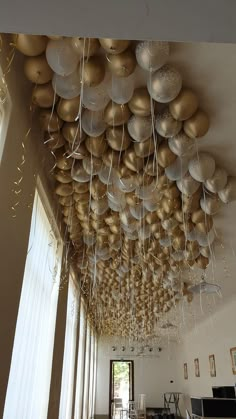 the ceiling is decorated with balloons and streamers in gold and silver colors, hanging from the ceiling