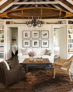 a living room filled with furniture and pictures on the wall above it's fireplace