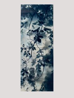 an abstract painting with leaves and branches in blue, black and white colors on a gray background