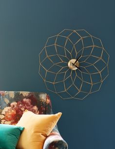 a living room with a couch, chair and decorative wall hanging on the blue wall