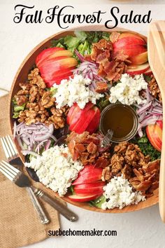 a salad with apples, onions, cheese and dressing in it on a wooden platter