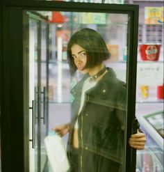 a woman standing in front of a refrigerator