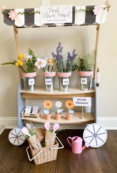 a flower shop display with flowers and potted plants on the shelf next to it