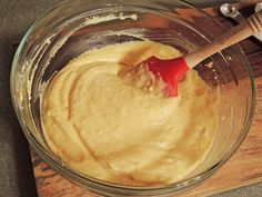 a wooden spoon mixing batter in a glass bowl