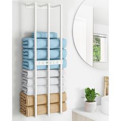 a towel rack with towels hanging on it in a bathroom next to a sink and mirror