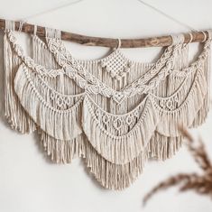 a white wall hanging with tassels on it