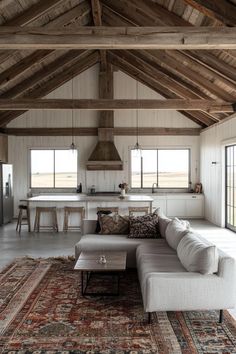 a living room filled with furniture and a large rug on top of a wooden floor