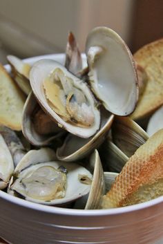 a white bowl filled with clams and bread