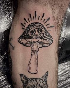 a man's leg with a mushroom and cat tattoo on it