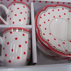 red and white dishes in a box with polka dot designs on the plates, cups and saucers