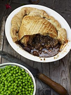 there is a pie and peas in the bowl on the table next to each other