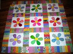 a quilted table topper with flowers and butterflies on the center, sitting on a wooden floor