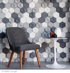 a chair and table in front of a wall with hexagonal tiles on it