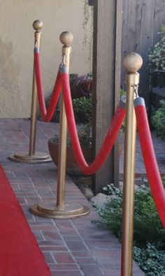 some red and gold poles on the side of a building with a red carpet in front of them