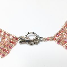 *Description: Beautiful hand made beaded collar necklace in shades of pink Czech glass beads; iridescent and darker pink. Teardrop shaped light pink iridescent beads are woven into the design as a drop bead. Silver tone decorative toggle clasp. Beautiful! This would be a great addition to your vintage jewelry collection or make a great vintage gift! *Approximate Measurements: Length - 17 Inches, Width - 1 Inch, Weight - 1.2 Ounces *Condition: Great vintage condition. May see signs of wear under Handmade Pink Choker With Round Beads, Pink Handmade Choker With Round Beads, Handmade Pink Crystal Necklaces For Party, Handmade Pink Crystal Necklace For Party, Handmade Pink Crystal Necklaces With Round Beads, Handmade Pink Crystal Bead Necklace, Pink Beaded Teardrop Jewelry, Pink Teardrop Beaded Jewelry, Pink Beaded Crystal Necklace With Adjustable Fit