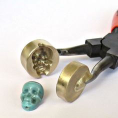 a pair of pliers with two skull heads in the middle one has a hole puncher