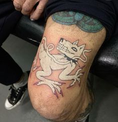 a man with a tattoo on his leg that has a white cat sitting on it