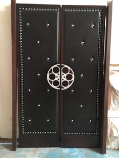 an open door with a circular design on the front and side panels in black leather