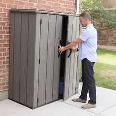 a man opening the side of a storage shed