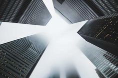 looking up at tall buildings in the fog