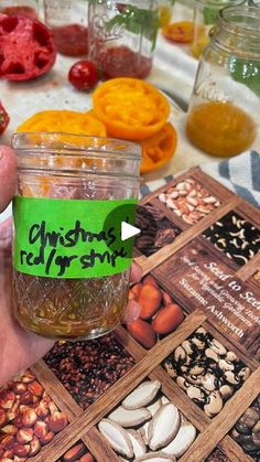 a person holding up a jar filled with food on top of a table covered in pictures