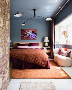 a bedroom with blue walls and purple bedding