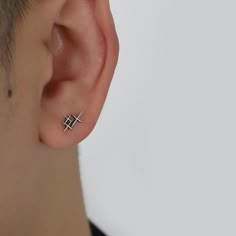 a close up of a person wearing a pair of ear piercings on their ears