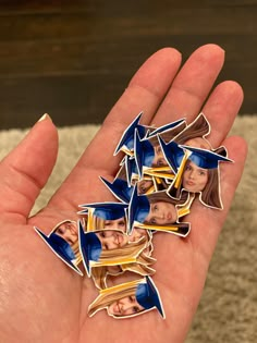 a hand holding several pictures of people in graduation caps and gowns on their fingers