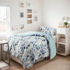 a bedroom with white walls and blue bedding