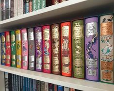 a row of books on a book shelf in a library with many different colored covers