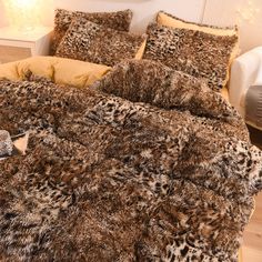 a leopard print comforter and pillows on a bed