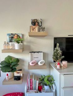 three shelves with various items on them in front of a tv and desk top computer