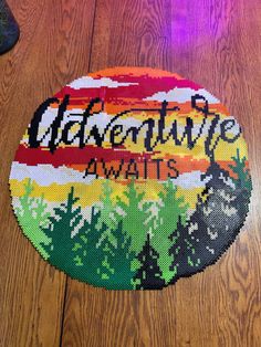 a round rug with the words adventure awaits on it