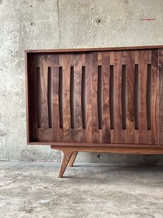 a wooden cabinet sitting on top of a cement floor