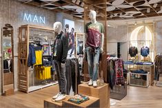 two mannequins are standing on display in a clothing store