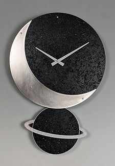 a black and silver clock with two circles on it's face, in front of a gray background