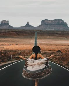 a woman is walking down the road with her arms spread out in front of her