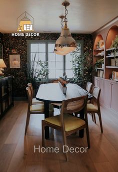 a dining room table with chairs and a potted plant in the center is shown