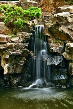 there is a waterfall in the middle of some rocks