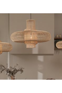 three chandeliers hanging from the ceiling in a room with mirrors and vases