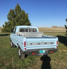 a blue pick up truck parked in the grass