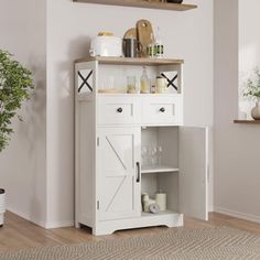 a white cabinet with drawers and shelves in the corner next to a potted plant