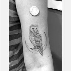 an owl sitting on top of a crescent tattoo